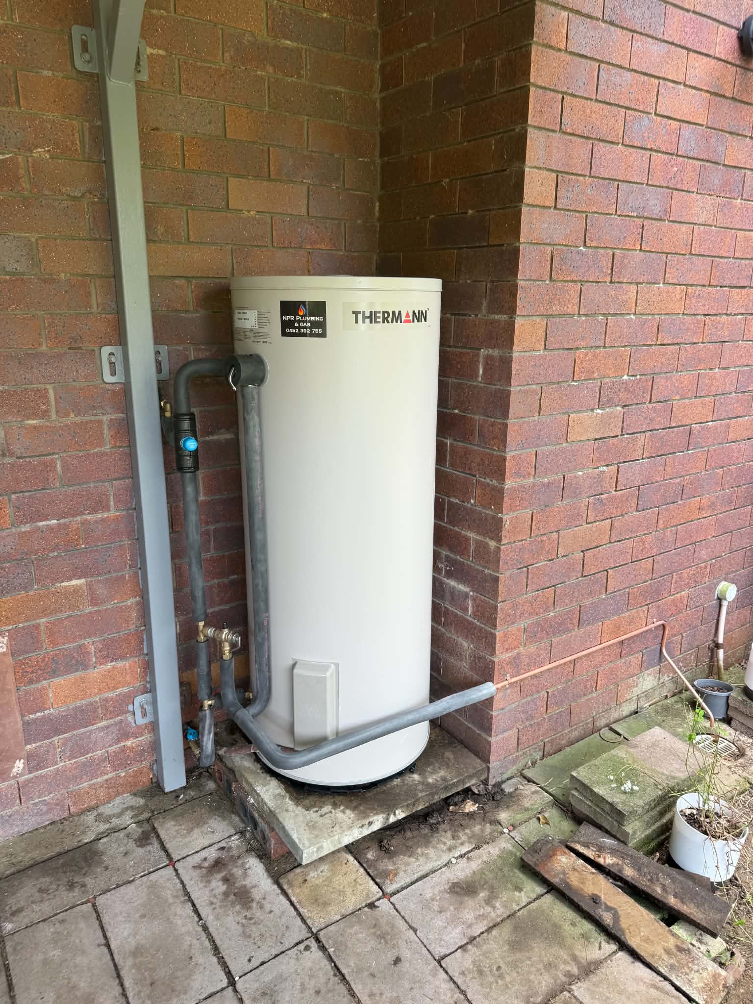 Thermann hot water system installation on a brick wall