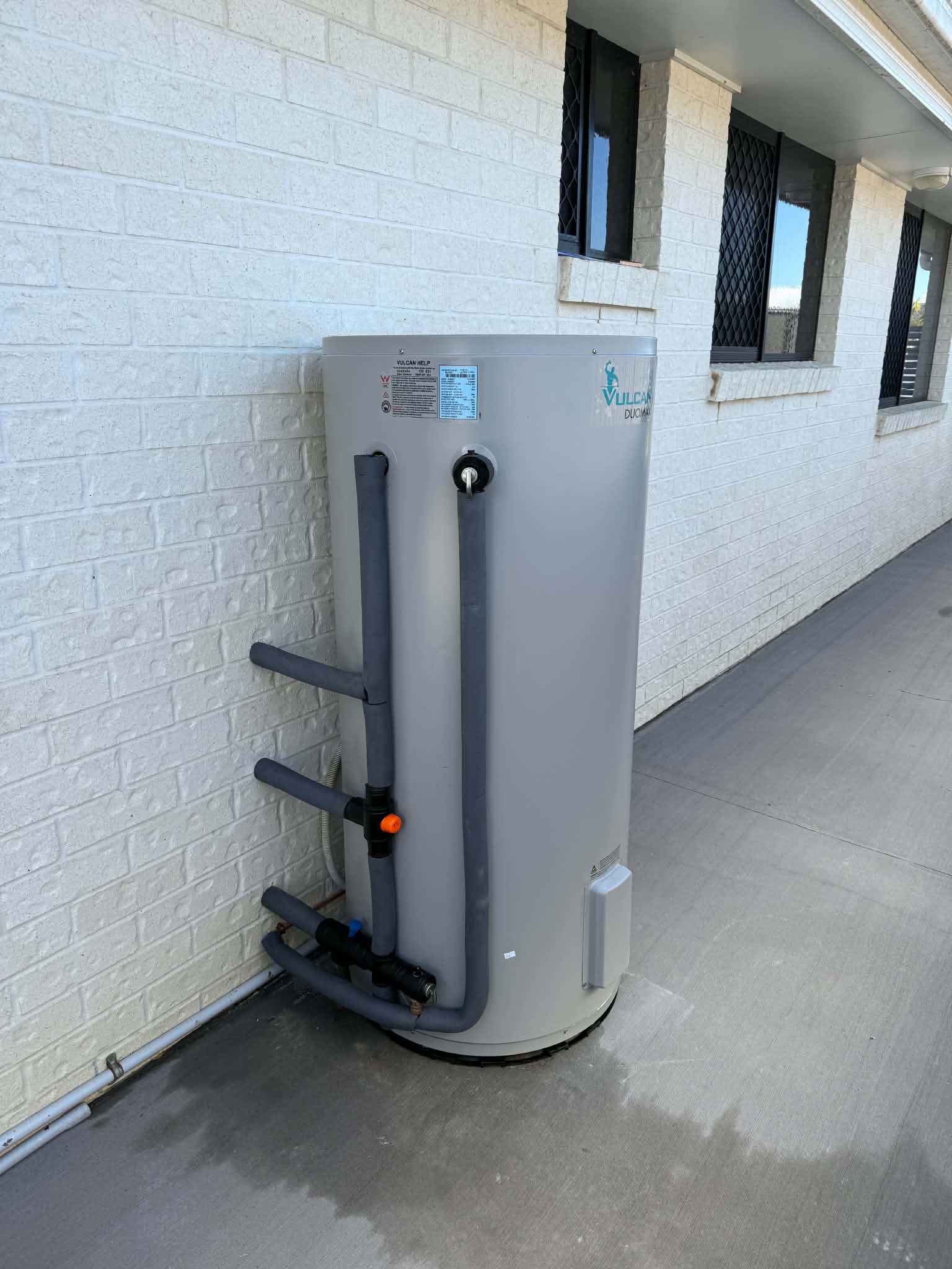 Vulcan hot water system installed against a brick wall